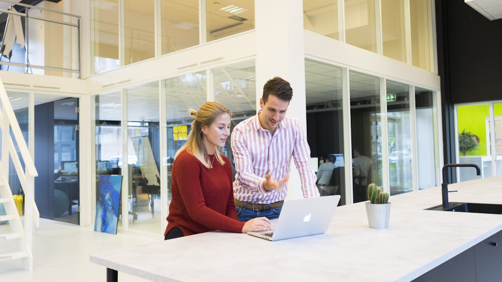 Photo of a Man and Woman Using a Laptop Computer